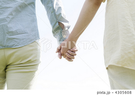 手をつなぐカップルの手元の写真素材
