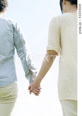 手をつなぐカップルの後姿の写真素材
