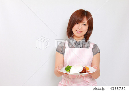 主婦ハンバーグ皿を持つの写真素材