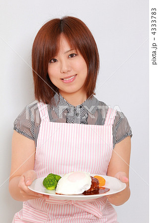 主婦ハンバーグ皿を持つの写真素材