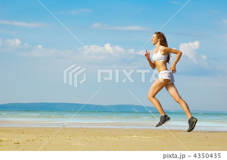 Young woman running alone on the beach Young woman running alone on the beach 4350435