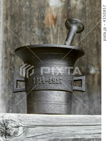 Ancient kitchen and medical utensil. Old metal mortar on wooden 4350957