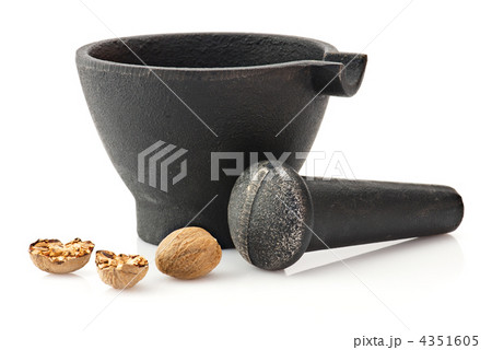 Kitchen utensil: mortar with pestle and nutmeg over white 4351605