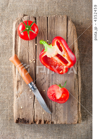 Fresh tomato, paprika, steel knife and vintage wooden cutting bo Fresh tomato, paprika, steel knife and vintage wooden cutting bo 4352459
