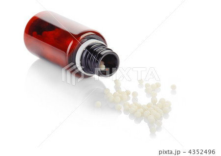 Bottle and globule of homeopathic medication on white background Bottle and globule of homeopathic medication on white background 4352496