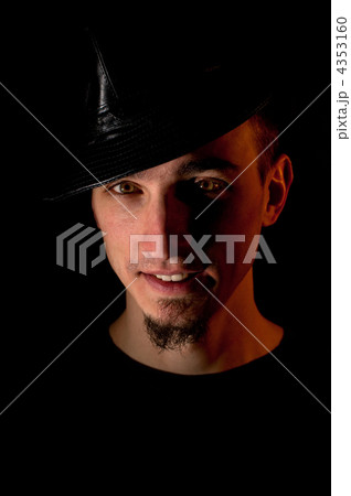 Studio portrait of smiling handsome man in hat over black backgr 4353160