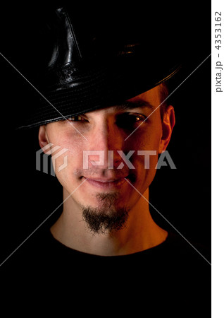 Studio portrait of smiling handsome man in hat over black backgr 4353162