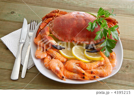 Crab with shrimp and parsley on a wooden table Crab with shrimp and parsley on a wooden table 4395215