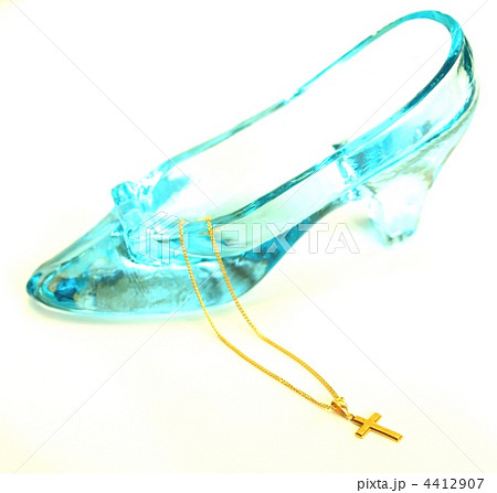 ゴールドのネックレスとガラスの靴 室内 白背景の写真素材