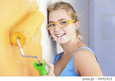 happy young woman painting a wall in  her room /  colorful life 4442453
