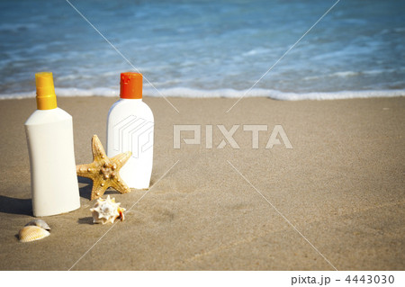 Suntan Lotion Flacons on the Beach with copy space 4443030