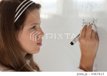 Schoolgirl is writing equation solution on whiteboard 4467615