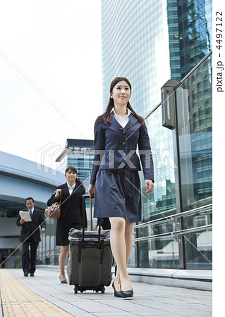 キャリーバッグを持ち出張に向かう女性ビジネスマンの写真素材