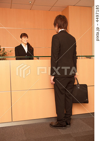 来客と笑顔で会話をする受付の女性 4497185