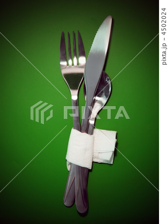 Table serving-knife,spoon,fork on green backdrop. 4502024