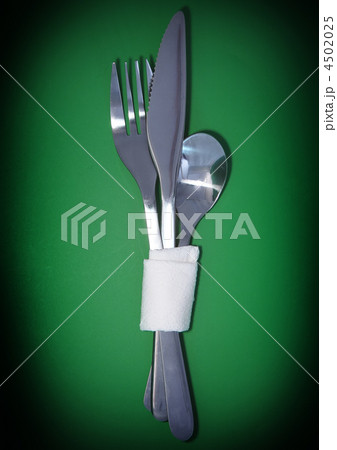 Table serving-knife,spoon,fork on green backdrop. Table serving-knife,spoon,fork on green backdrop. 4502025