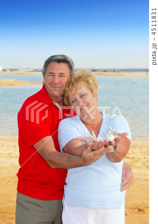 Elderly couple on the coast ,holding corals. 4511831