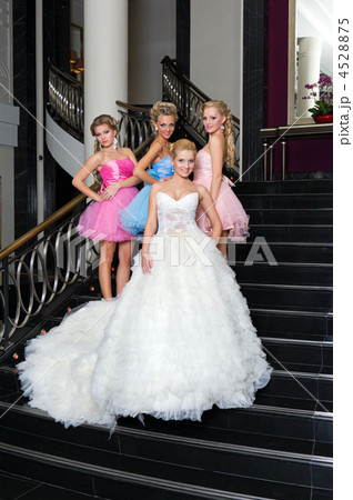 The bride with her bridesmaids on the stairs 4528875