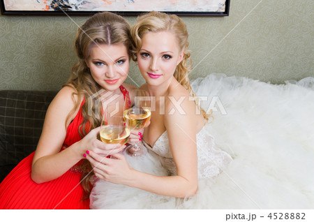 The bride and her bridesmaid with a glass of wine The bride and her bridesmaid with a glass of wine 4528882