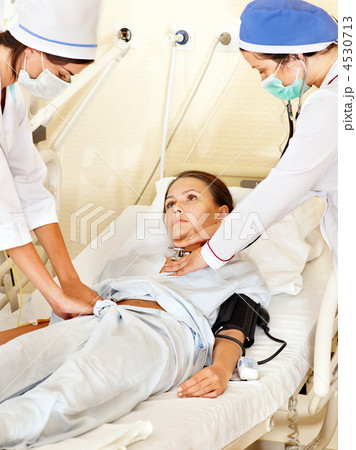 Doctor treats female patient with stethoscope. 4530713