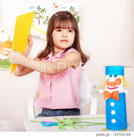 Child with scissors cut paper in play room. 4558336
