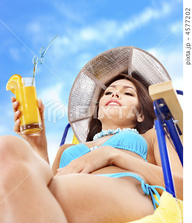 Girl in bikini drinking orange juice. 4577202