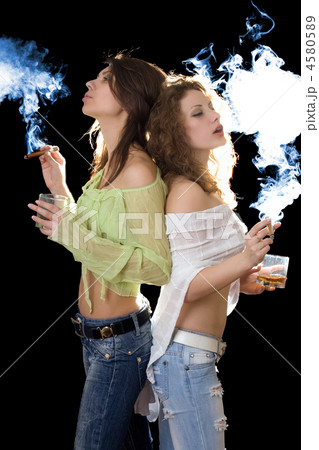 Two young pretty girlfriends with a cigars Two young pretty girlfriends with a cigars 4580589