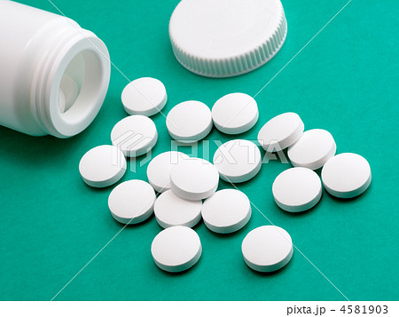 Pill from prescription bottle on green background 4581903