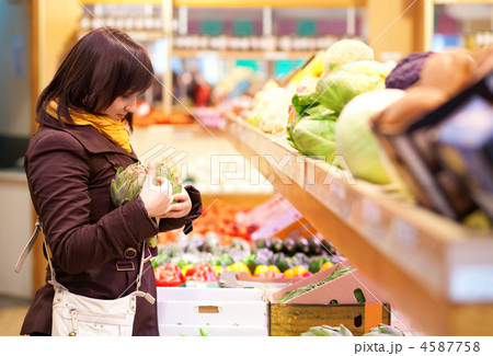 Beautiful girl selecting artichokes at market Beautiful girl selecting artichokes at market 4587758