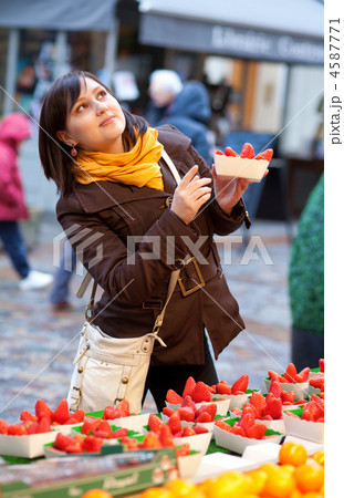 Beautiful girl selecting strawberries at market 4587771