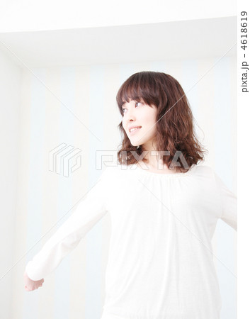 明るい部屋の中で両手を広げている笑顔の女性 明るい部屋の中で両手を広げている笑顔の女性 4618619