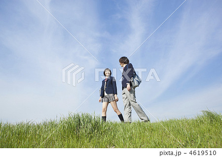 土手を歩く男女高校生の写真素材