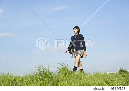 土手を歩く女子高校生の写真素材