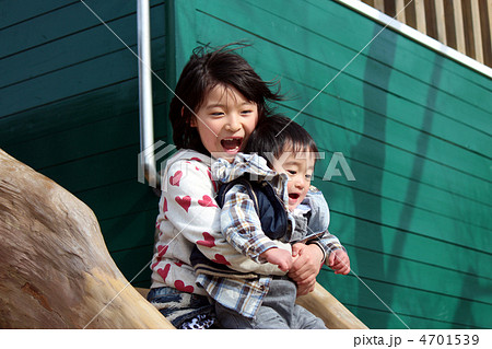 木のすべり台を一緒に滑る女の子と男の子の姉弟 木のすべり台を一緒に滑る女の子と男の子の姉弟 4701539