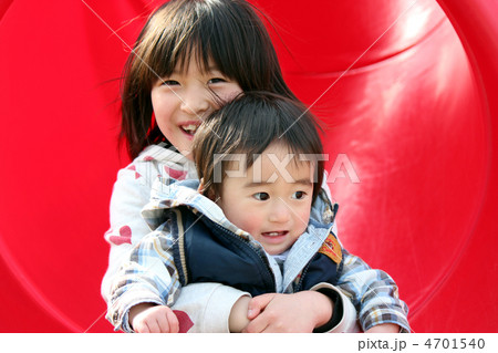 赤いすべり台を一緒に滑る女の子と男の子の姉弟 赤いすべり台を一緒に滑る女の子と男の子の姉弟 4701540