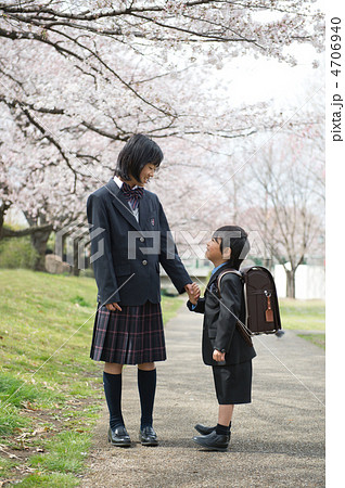 桜並木に立つ中学生と小学生の姉弟 4706940