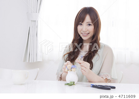 小さな花瓶に花を挿す女性 4711609