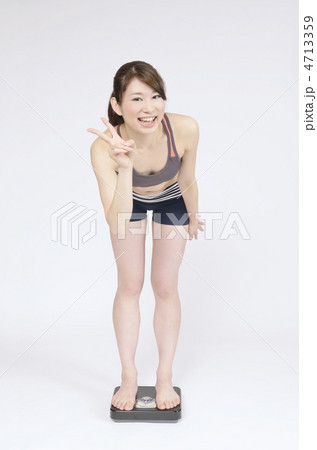 体重計に乗り喜ぶ女性 4713359