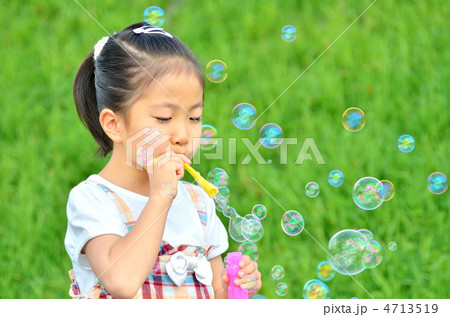 シャボン玉で遊ぶ女の子の写真素材