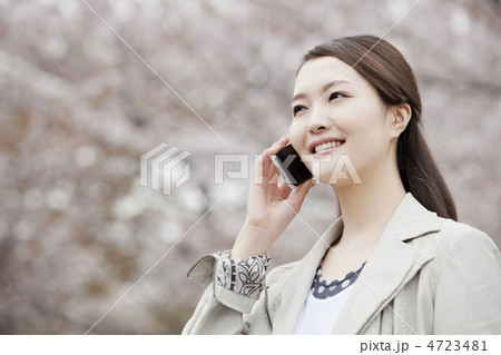 桜をバックにスマートフォンで通話をする女性 桜をバックにスマートフォンで通話をする女性 4723481