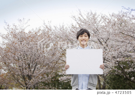 桜をバックにメッセージボードを持った男性 4723505