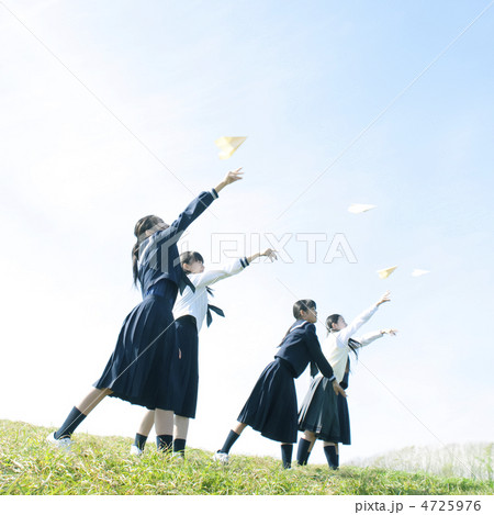 紙飛行機を飛ばす中学生の写真素材