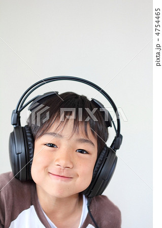ヘッドホンをつけて音楽を聴く笑顔の男の子の写真素材
