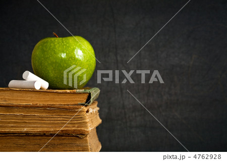 Chalk and green apple on old textbook Chalk and green apple on old textbook 4762928