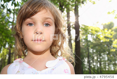 Portrait of little cute girl with curly blonde hair in white clo 4795458