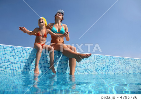 Mother with daughter sit on  parapet of pool and gladly lift  he 4795736