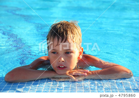 Little boy lies in swimming-pool and thoughtfully looks sideways Little boy lies in swimming-pool and thoughtfully looks sideways 4795860