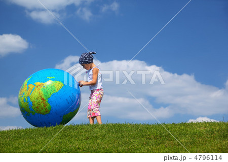 Girl stands on  grass in  day-time and plays with an inflatable 4796114