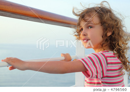 little curl girl standing on cruise liner deck, hands on rail, h 4796560