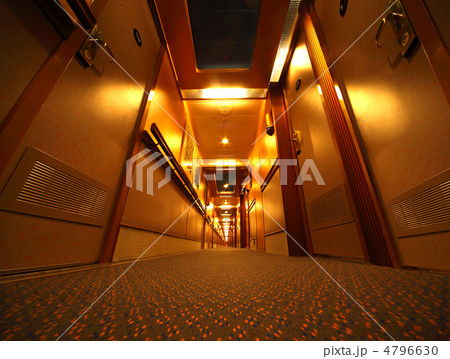 Narrow and long illuminated corridor with hotel rooms in cruise 4796630